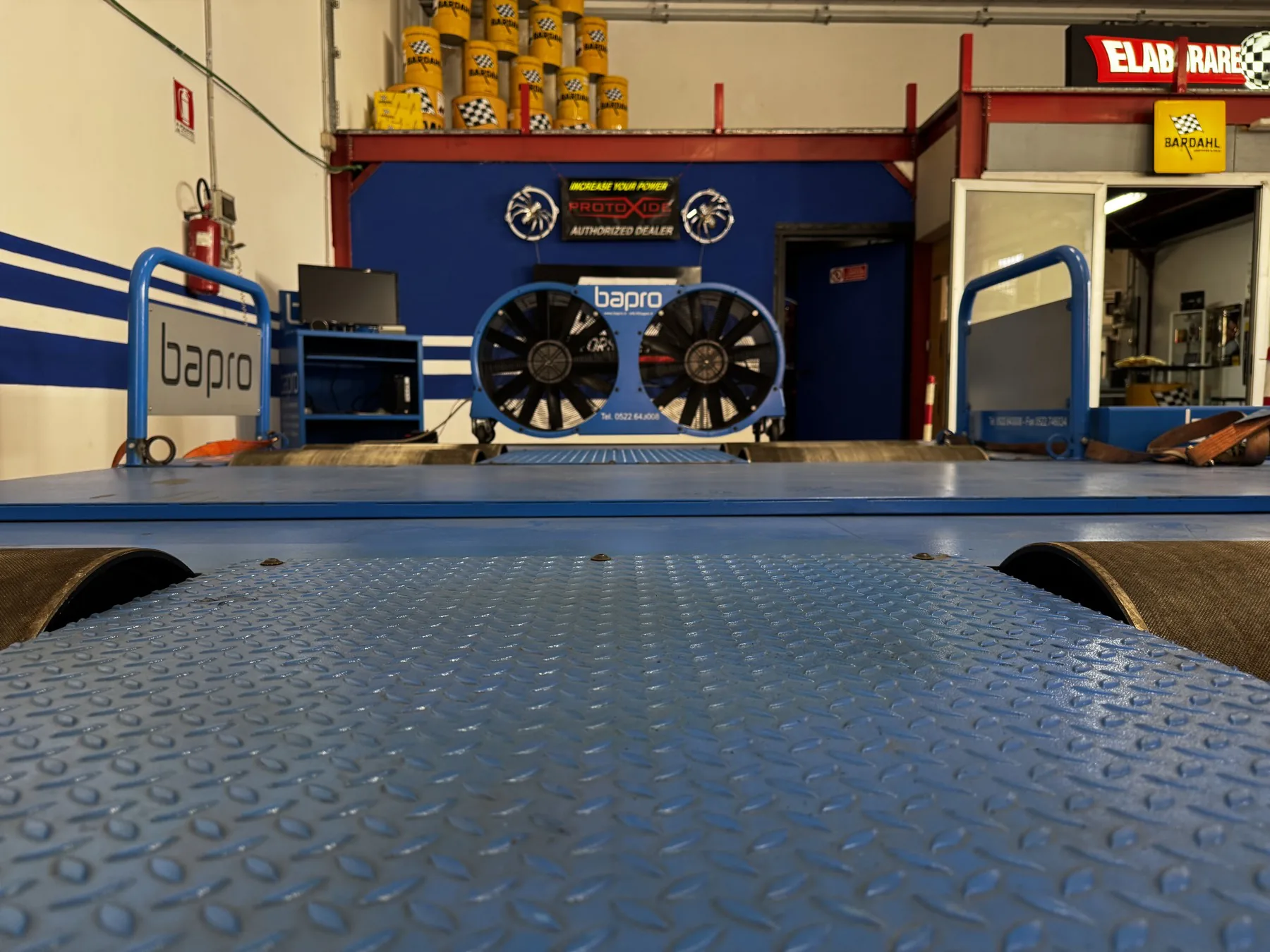 Interno dell'officina G. & C. Motorsport con ponte sollevatore e attrezzature